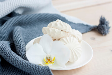 Fototapeta na wymiar Marshmallows. Vanilla sweet homemade marshmallows. Light composition with an Orchid flower. Sweet delicious dessert.