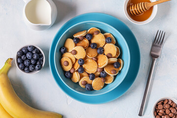 Trendy breakfast with mini pancakes, blueberries and chocolate chips.