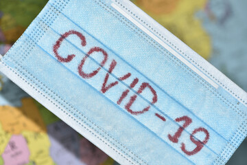 Obraz premium Mop washing away the inscription COVID-19 made from used medical face masks. Medical mask with the inscription covid 19. Pandemic is over