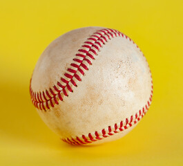 worn baseball isolated on yellow background, team sport