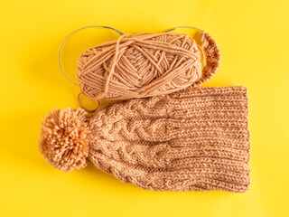 Handmade knitted winter hat on yellow background