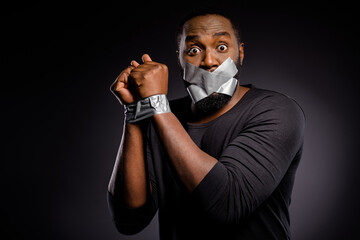 Photo of astonished afro american guy restrain arrested police hand adhesive taped lips close cover...