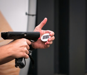 Hands holding a scanner and scanning a bar code