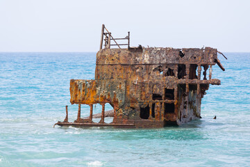 Rusty ship wreck remains surrounded by water near to Cyprus shores.