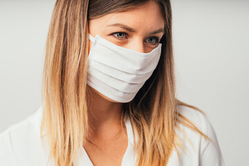 Beautiful confident young Caucasian girl with surgical mask . Close up. Covid-19 coronavirus. Professional student girl close up front portrait. Isolate 

