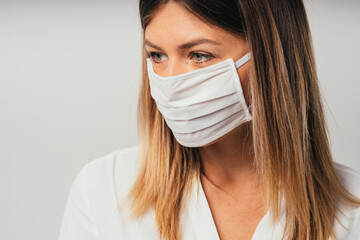 Beautiful confident young Caucasian girl with surgical mask . Close up. Covid-19 coronavirus. Professional student girl close up front portrait. Isolate 
