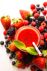 Overhead view of Mixed Berry smoothie on white rustic background - Healthy eating, Detox or Diet concept surrounded by ingredients 