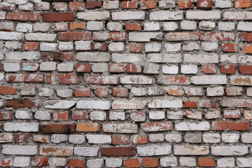 Close-up view of the old wall, roughly built of red and white bricks. Full frame urban texture, background or wallpaper, copy space