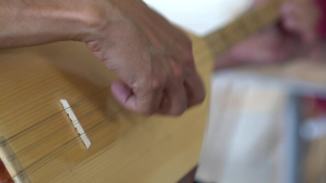 Male hands playing traditional music Instrument close up.Adult hobby course