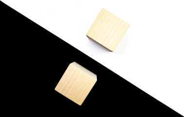 Yin Yang concept in the form of black and white paper with two wooden cubes on it.