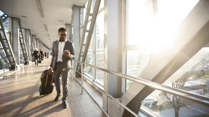 Entrepreneur Man Using Mobile Phone Texting Walking In Airport Terminal