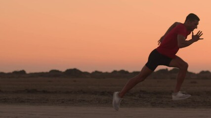Sprinter practising start position before running in nature after sunset