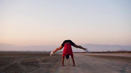 Man warming up with acrobatic exercises before sports training outdoors