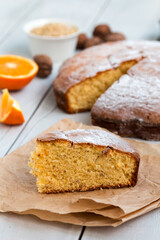 orange and walnut cake on black background.