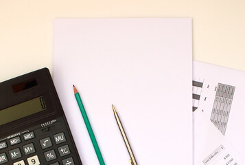 Sheets of paper for the office are next to a calculator. A set of pencils.