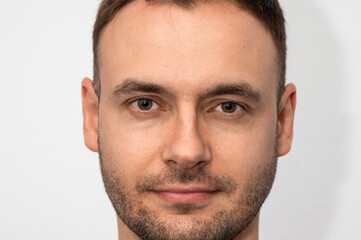 Fototapeta premium Close-up portrait of a handsome young guy with stubble and a new haircut in a barbershop. face of a man with a mustache and beard