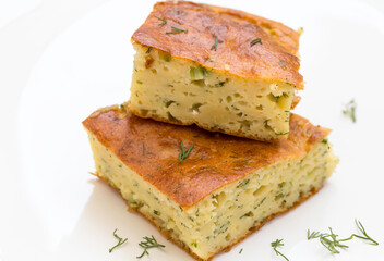 Pie with zucchini, egg and herbs on the plate