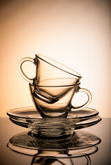 Two empty transparent coffee cup isolated on orange background.