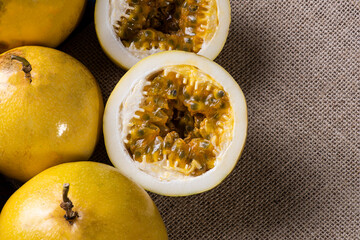 Passion fruit cut in half and some whole passion fruit. Wood background.