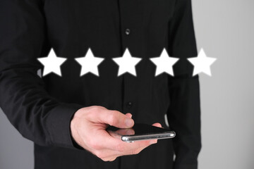 Man with a phone leaving a positive feedback, five stars rate.