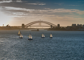 Obraz premium Amazing view of sailboats in Sydney golf at sunset with Sydney Harbour Bridge in the background