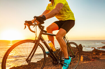 Fototapeta na wymiar Biking cyclist riding road bike with smartwatch athlete training at sunset outdoor cycling. Sport smart watch fitness.