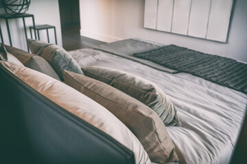 Bed in luxury bedroom at hotel room with black leather headboard and decoration pillows, modern...