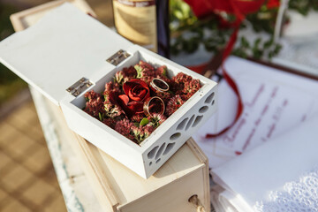 Two gold wedding rings in a beautiful wooden casket with green moss. Wedding accessories. Bride...