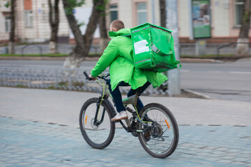 Delivery of food to homes and offices by courier on a Bicycle. Fast food delivery from restaurants.