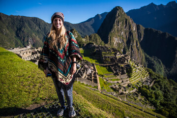 Blonde young woman smiling at the camera in machu picchu - obrazy, fototapety, plakaty