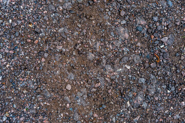 Textured background of small stones, sand and old crushed asphalt.