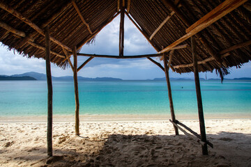 View of the tropical beach from under the awning that protects tourists from the sun