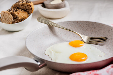 Fried egg. view of two fried eggs on a frying white pan.