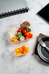Healthy food in lunch box, on working table with laptop