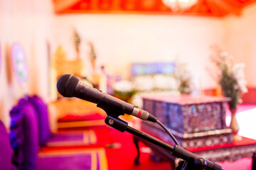 Microphone with blurry indoor location for Buddhist activities. The concept of speaker.