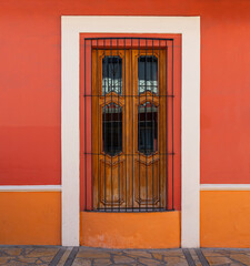 Colorful colonial style facade with window, San Cristobal de las Casas, Chiapas, Mexico.