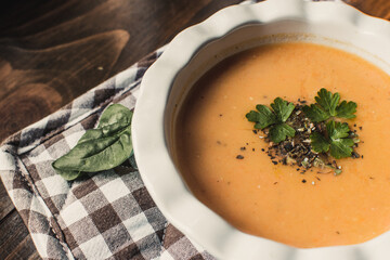 Pumpkin and carrot cream soup on dark wooden background. Top view.