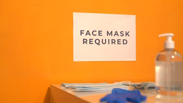 Stock video of entrance to a commerce where it is required to wear a medical mask and use disinfectant gel to avoid spreading the covid-19. Reopening and adaptation of schools to the new normal.