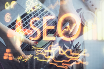 Double exposure of woman hands working on computer and seo hologram drawing. internet search concept.