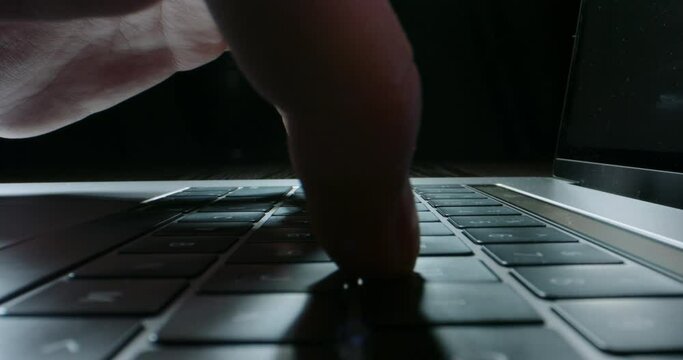 Unrecognizable worker using laptop computer, actively typing on keyboard. Fingers pressing keyboard buttons, isolated on black background technology concept close up 4k video