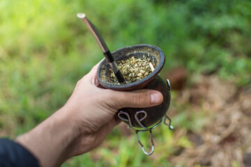 hand grabbing a bowl of mate, yerba mate