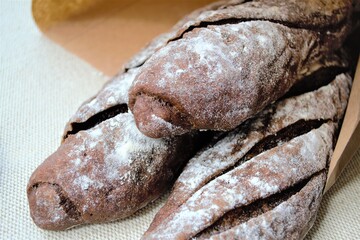 Close-up rye malt homemade french baguettes in a craft bag. In natural daylight
