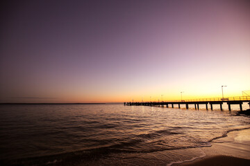 Fototapeta na wymiar Long jetty into beach at sunset