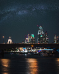 Bright nigh skyline of London city with the financial district skyscrapers, St Paul's Cathedral and the Thames river 