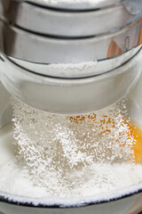 The process of cooking. The cook pours milk into the dough.