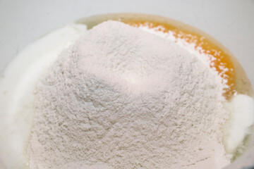 The process of cooking. The cook pours milk into the dough.