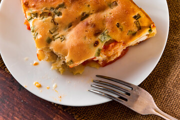 Homemade pie with chicken, herbs and tomatoes on a plate.