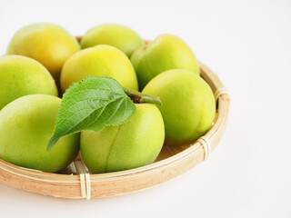 葉のついた青梅を白背景で
