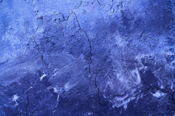 Texture cracked stucco on the wall in deep blue, a modern trend in advertising and design.