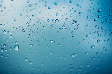 water drops on glass window, green and blue background